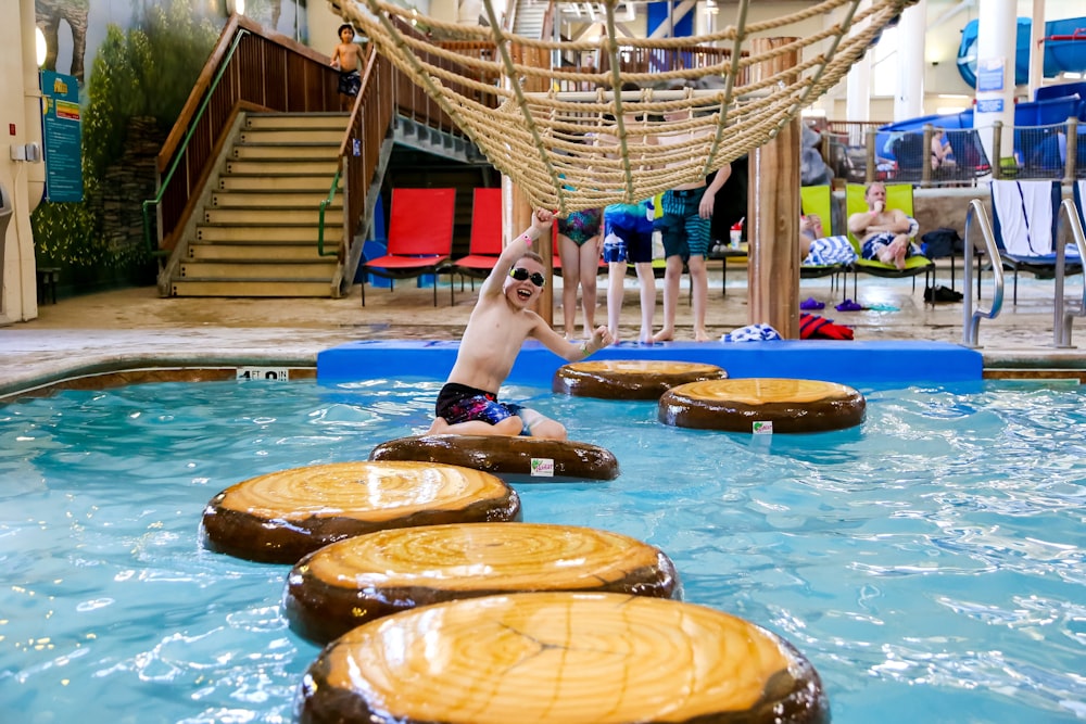 a young boy is playing in the pool