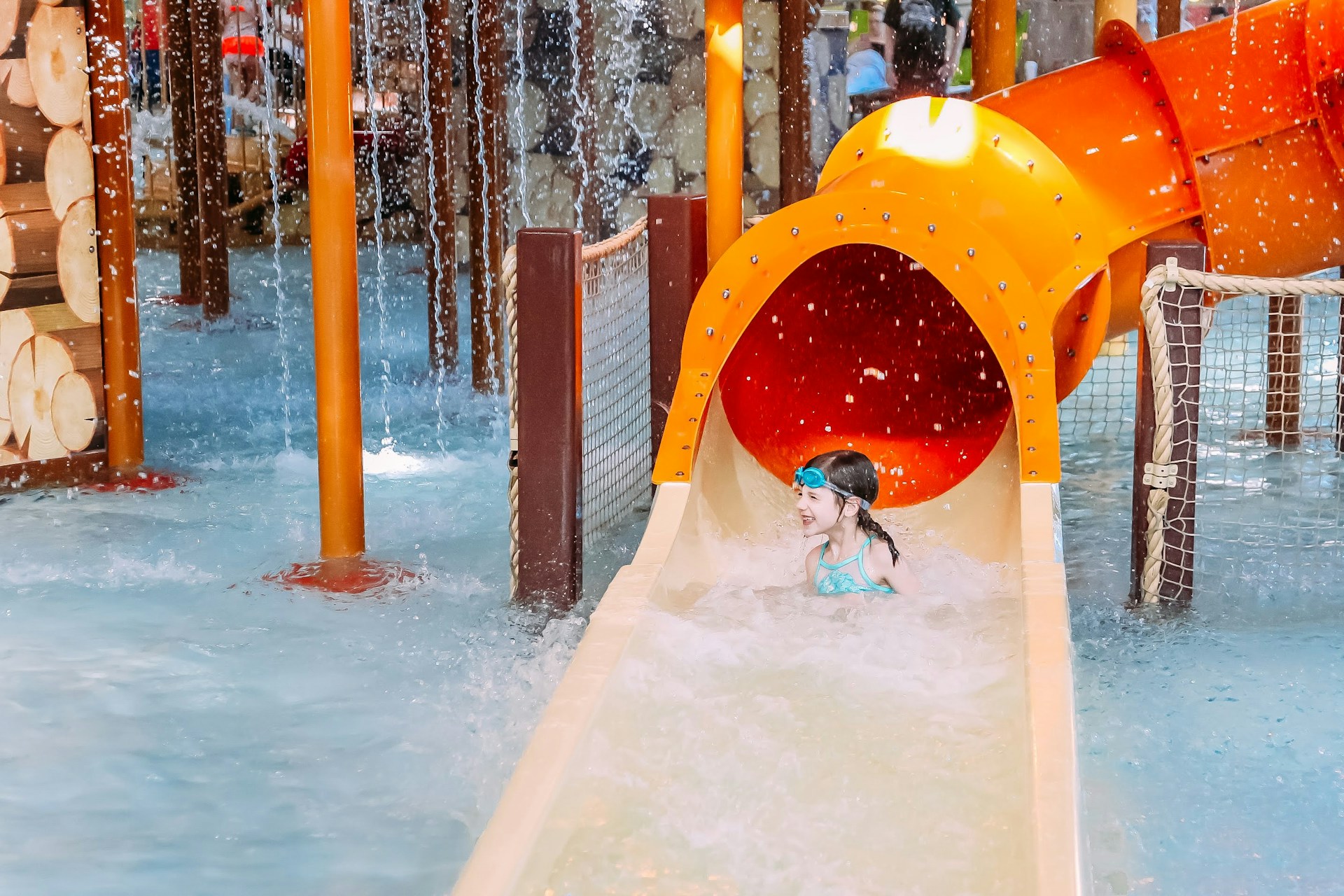 a child playing in a water park with a slide