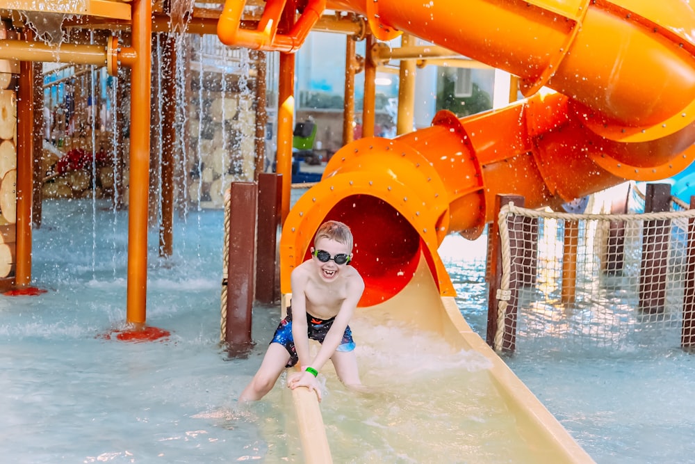 a young boy on a water slide at a water park