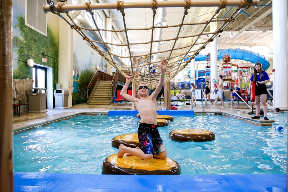 a young boy is playing in a water park
