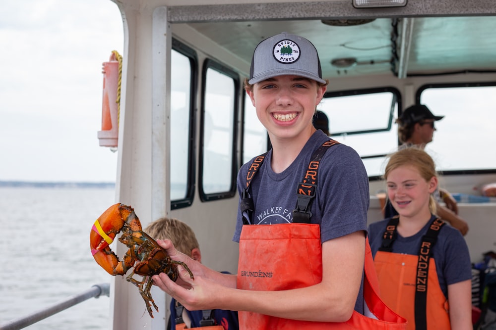 a boy holding a crab on a boat