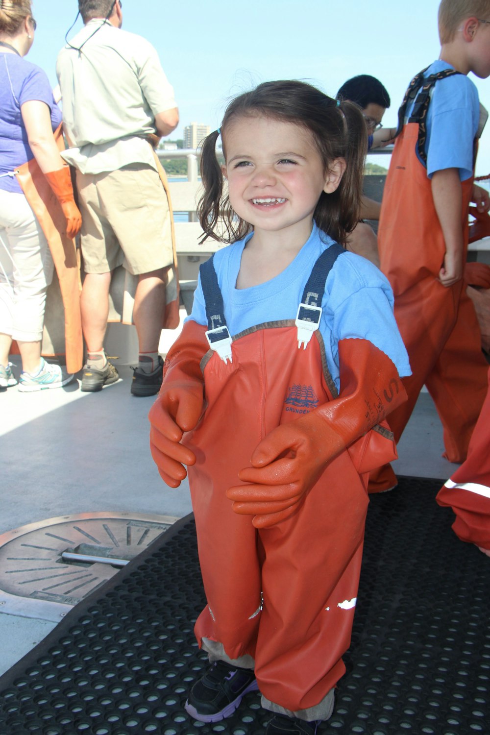 a little girl in a red and blue jumpsuit