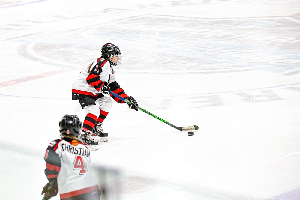 a couple of people playing a game of ice hockey