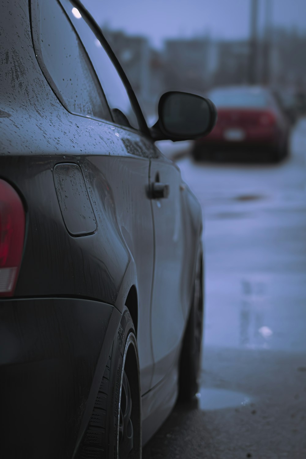 a car parked on the side of the road in the rain