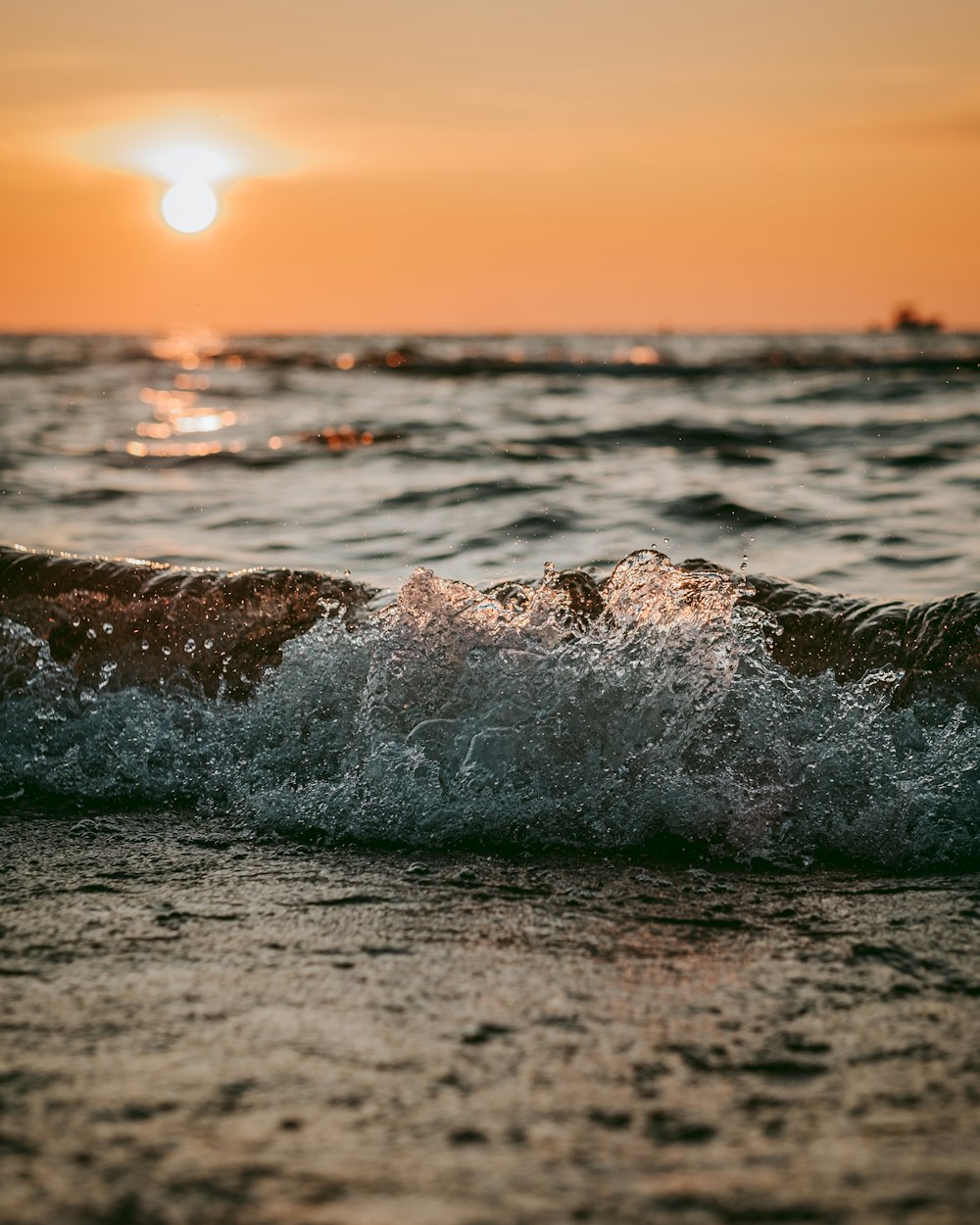 the sun is setting over the ocean waves