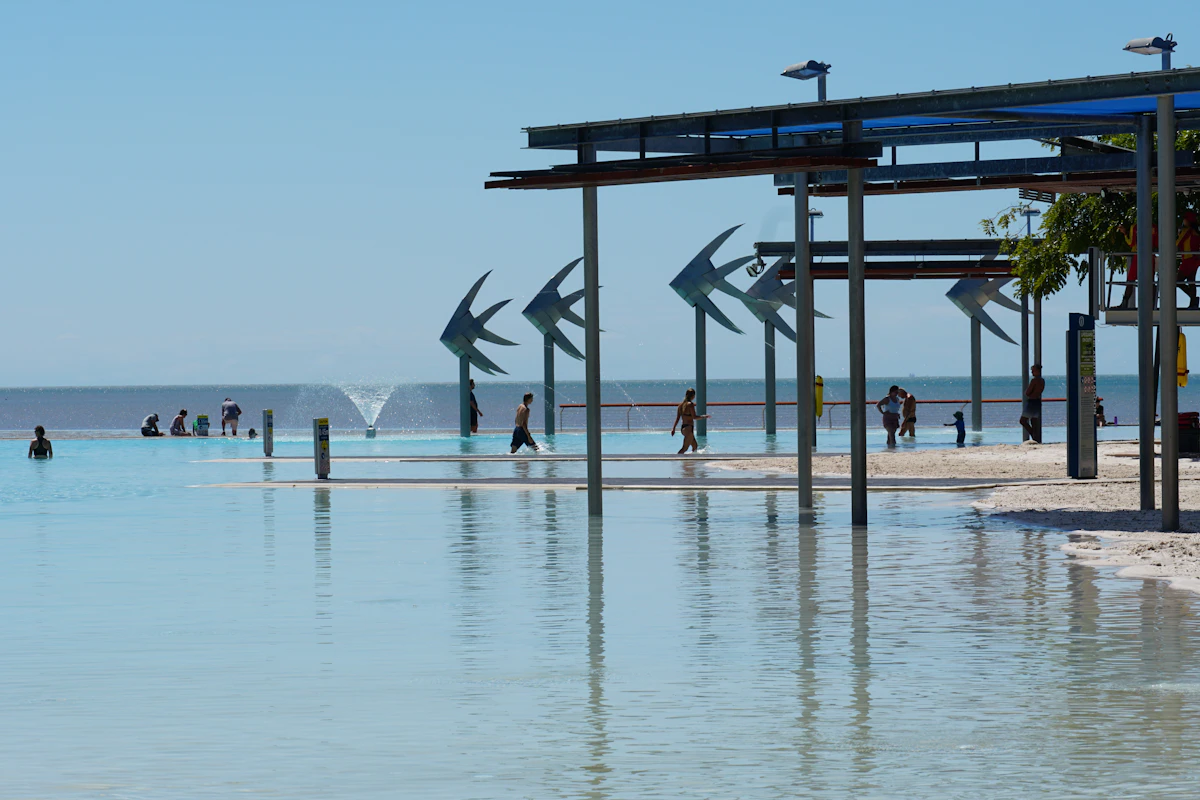 People walking along the Cairns waterfront beside the Coral Sea