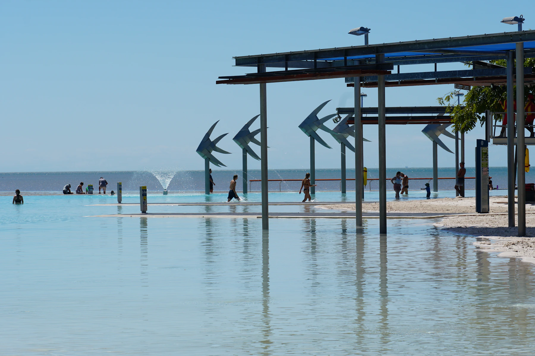 People walking along the Cairns waterfront beside the Coral Sea