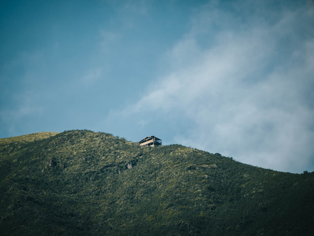 una casa asentada en la cima de una exuberante ladera verde