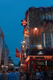 a crowd of people walking down a street next to tall buildings
