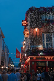 a crowd of people walking down a street next to tall buildings