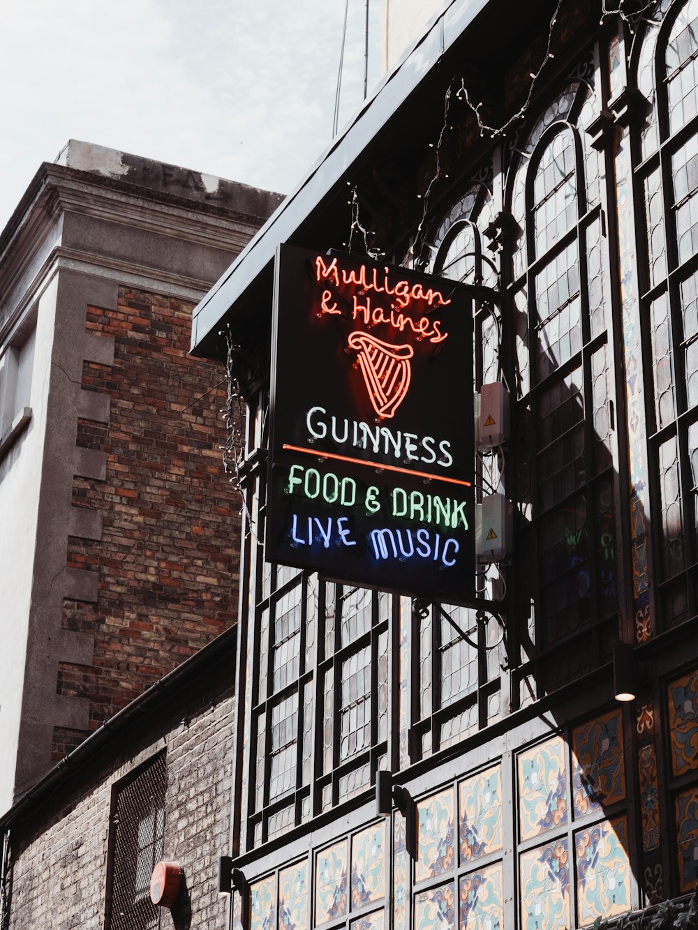 a restaurant sign hanging from the side of a building