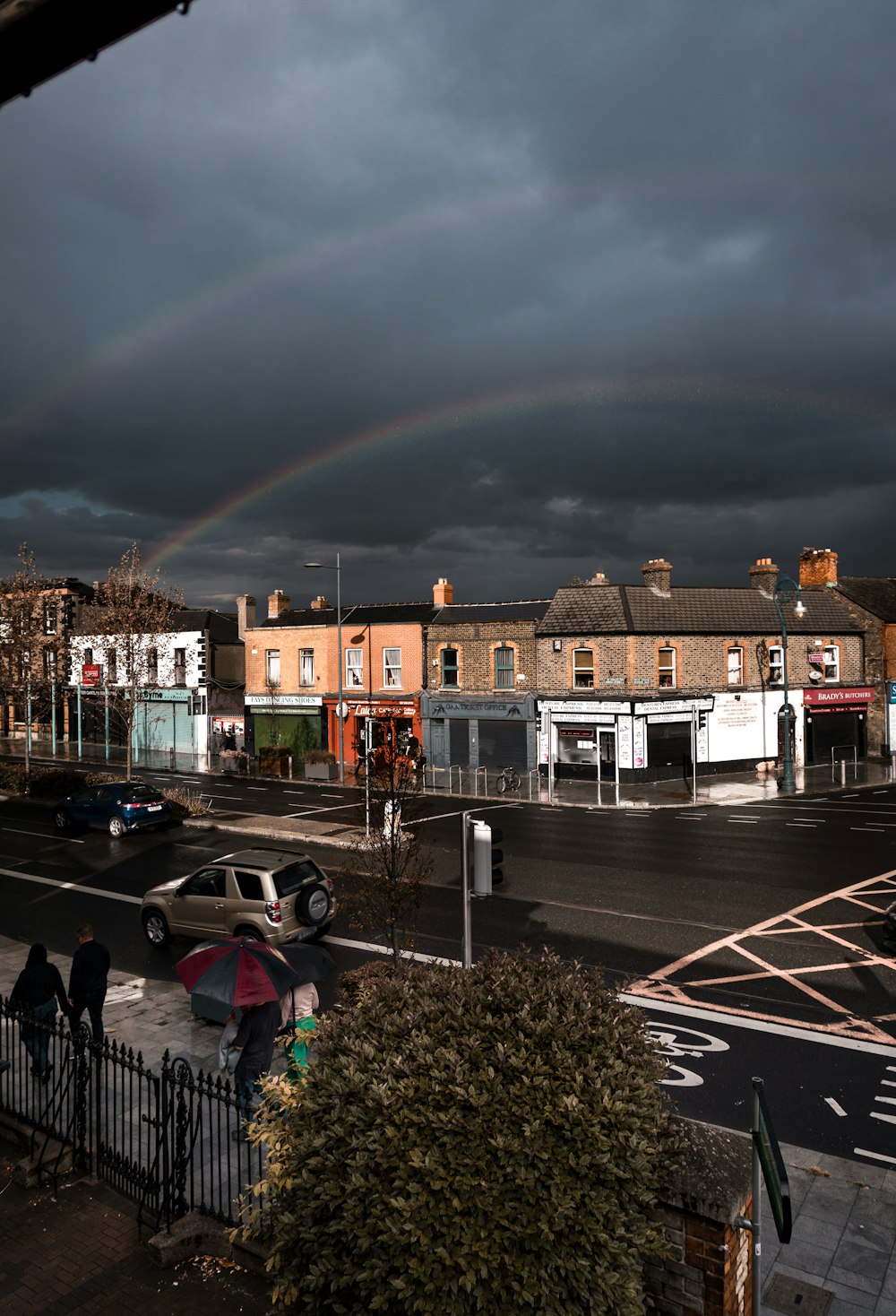 a rainbow in the sky over a city street