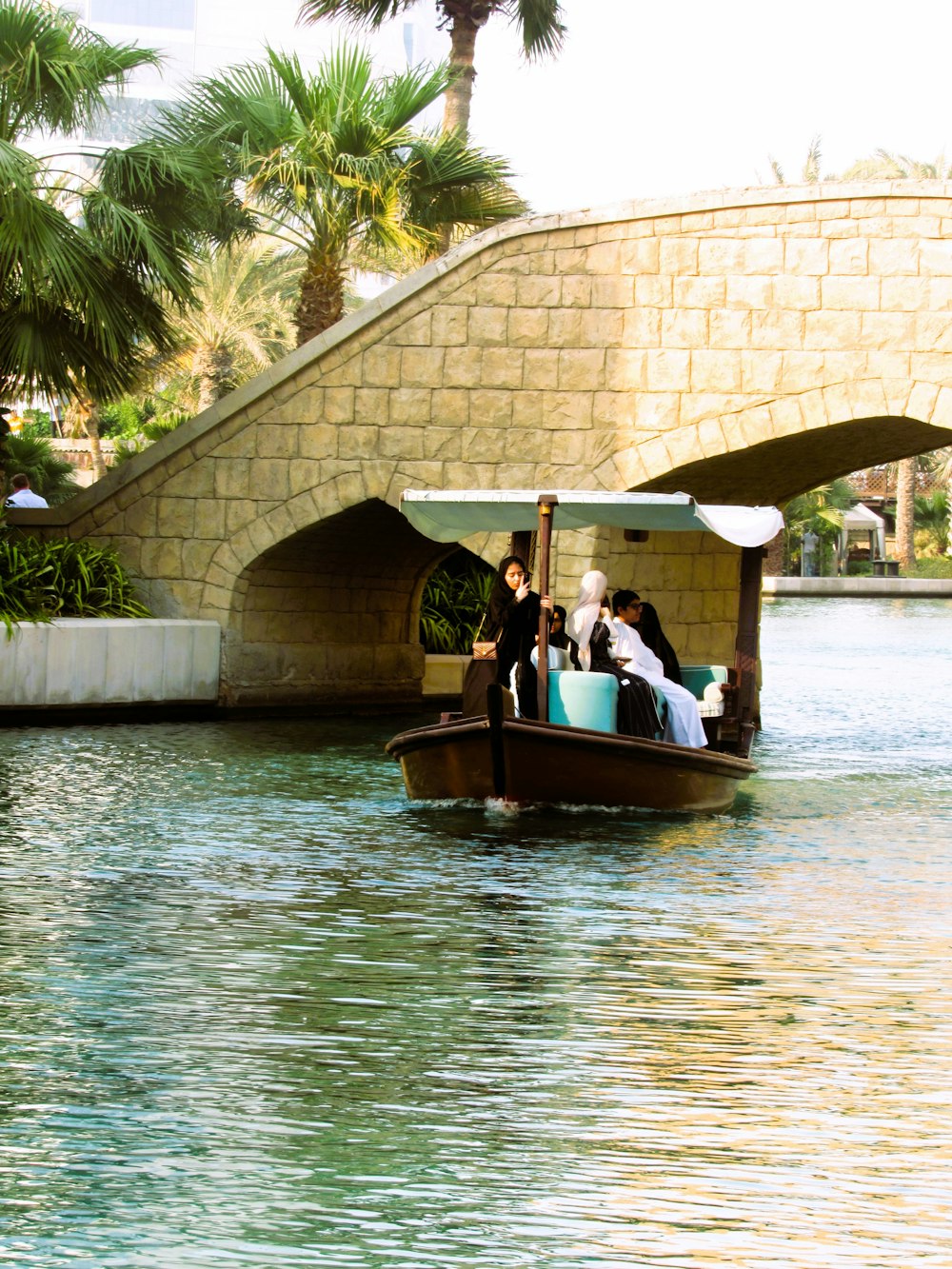 a group of people riding in a boat under a bridge