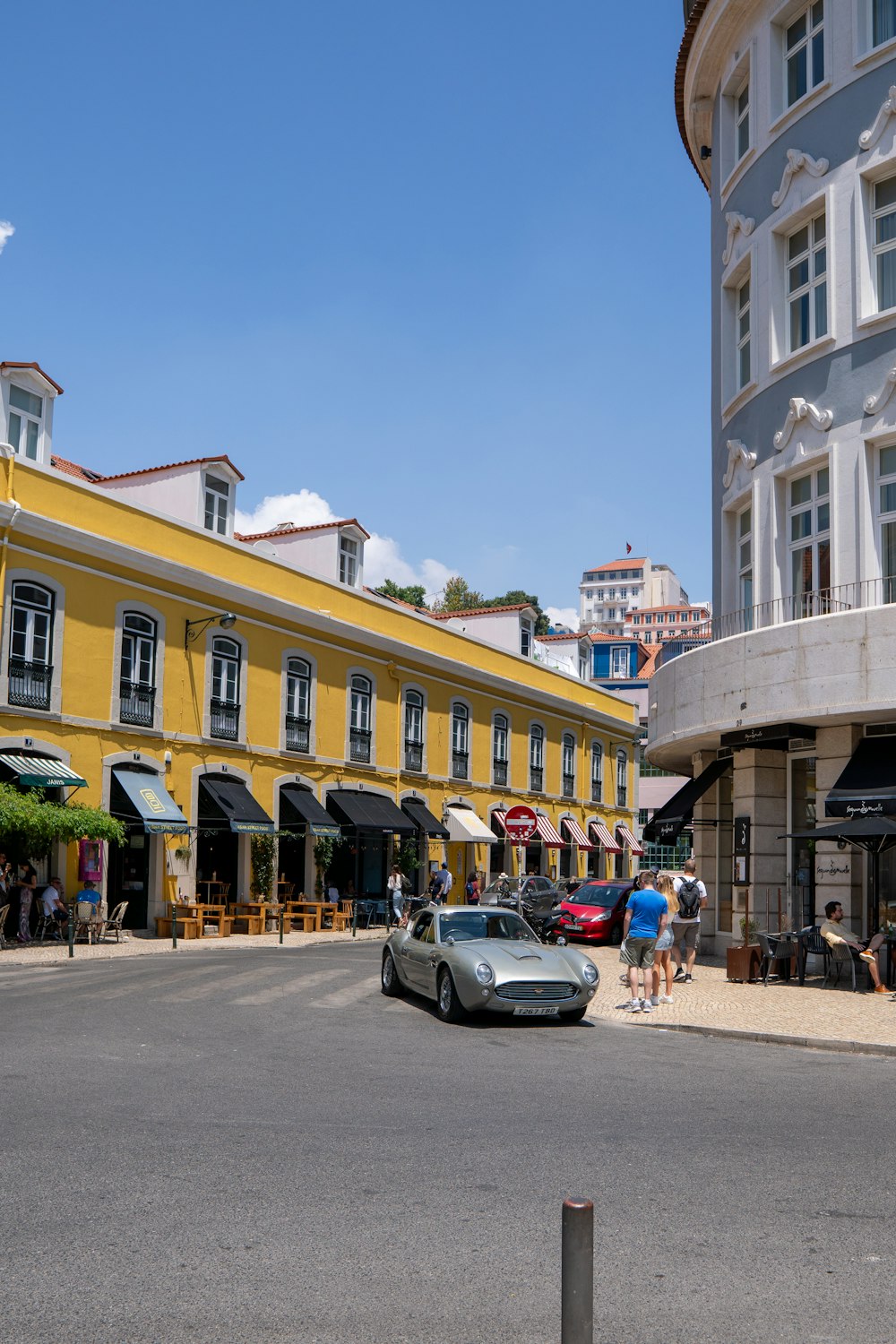 a car is parked in front of a yellow building