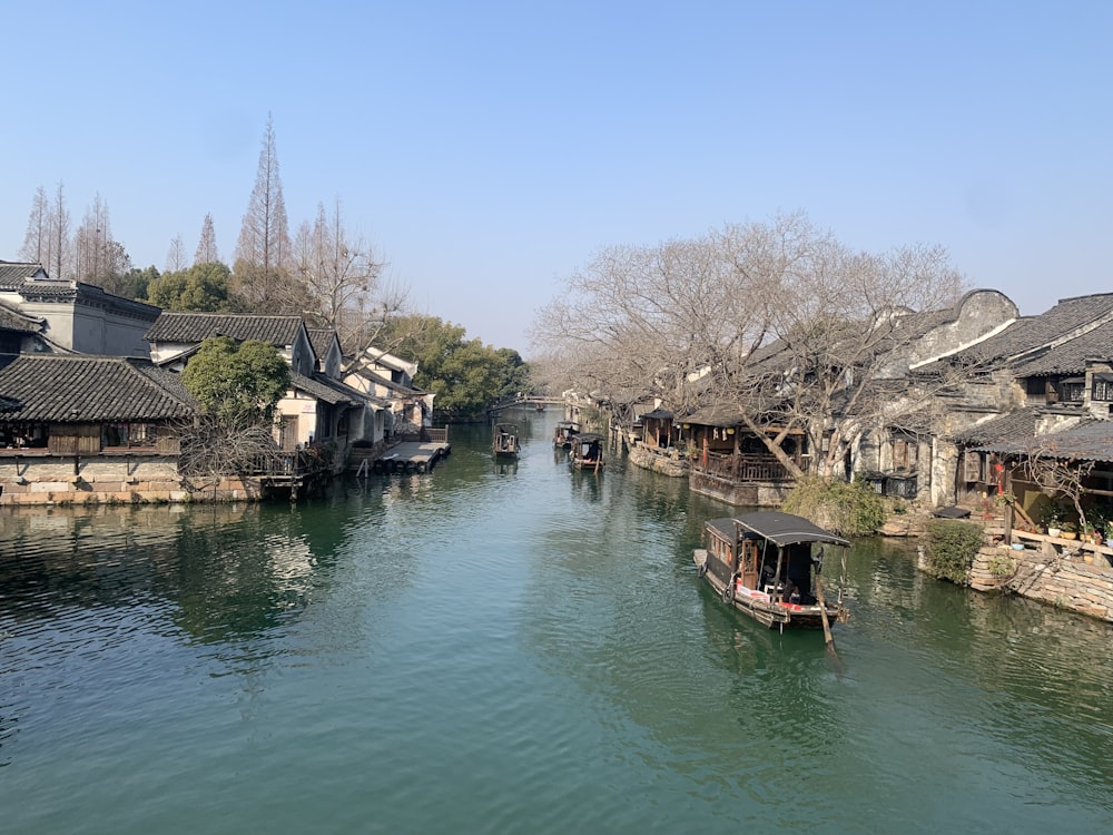 a small boat traveling down a river next to houses