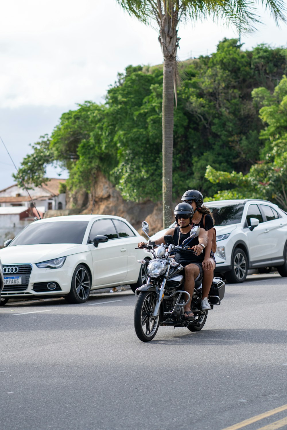 two people riding a motorcycle down a street