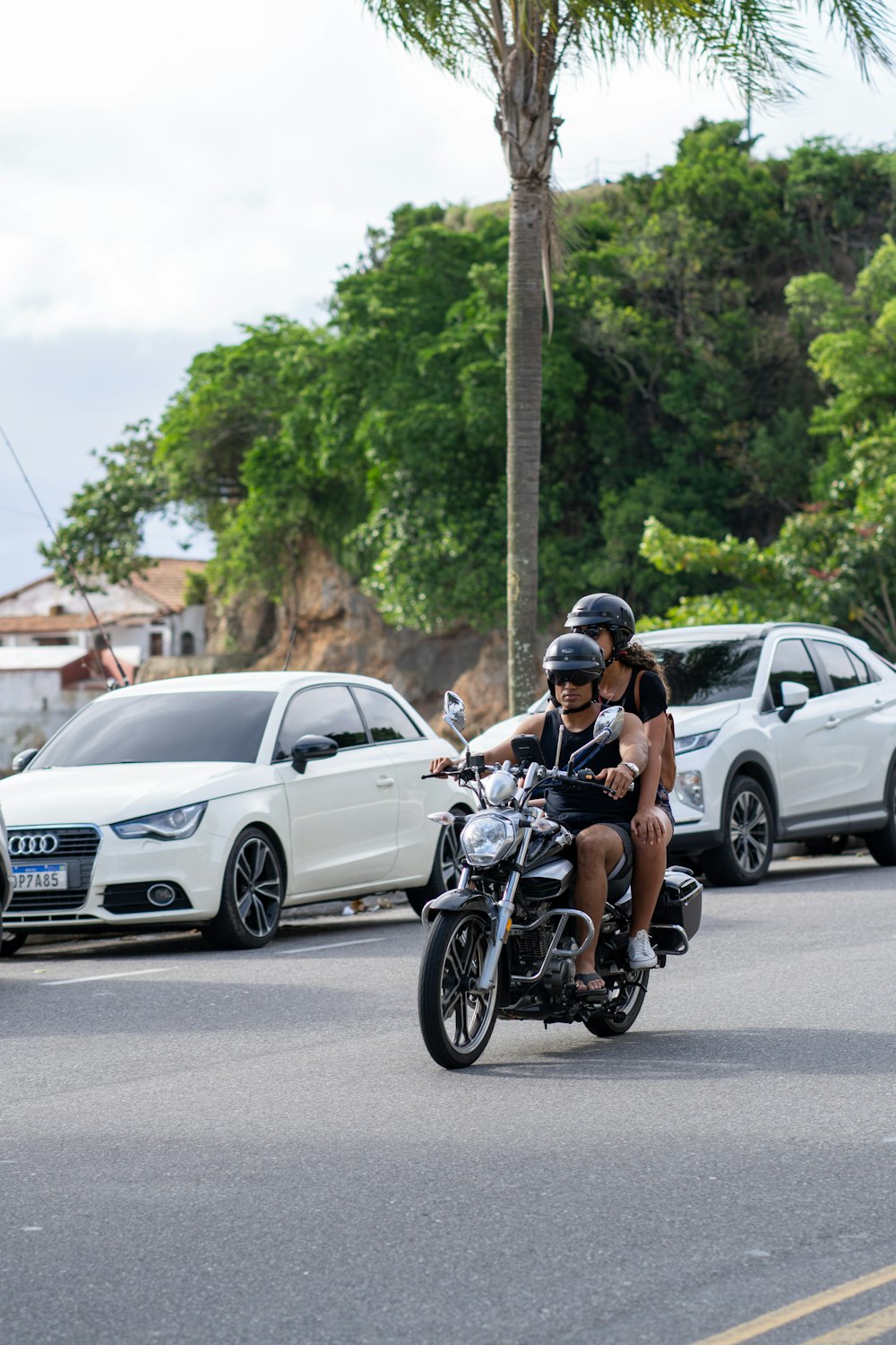 Zwei Personen fahren mit einem Motorrad eine Straße entlang