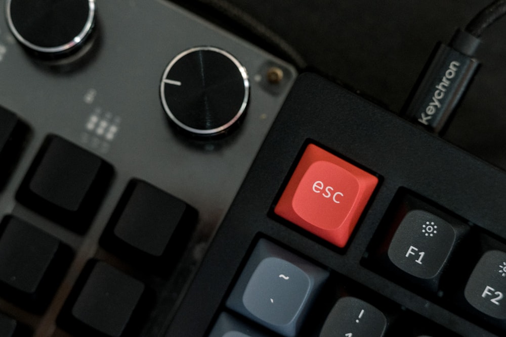 a close up of a keyboard with a red button