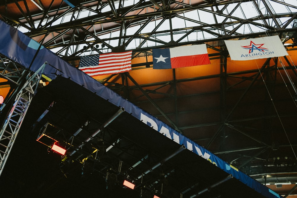 a group of flags hanging from the ceiling of a building