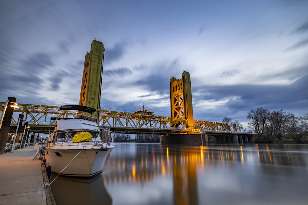 a boat is docked at a dock with a bridge in the background