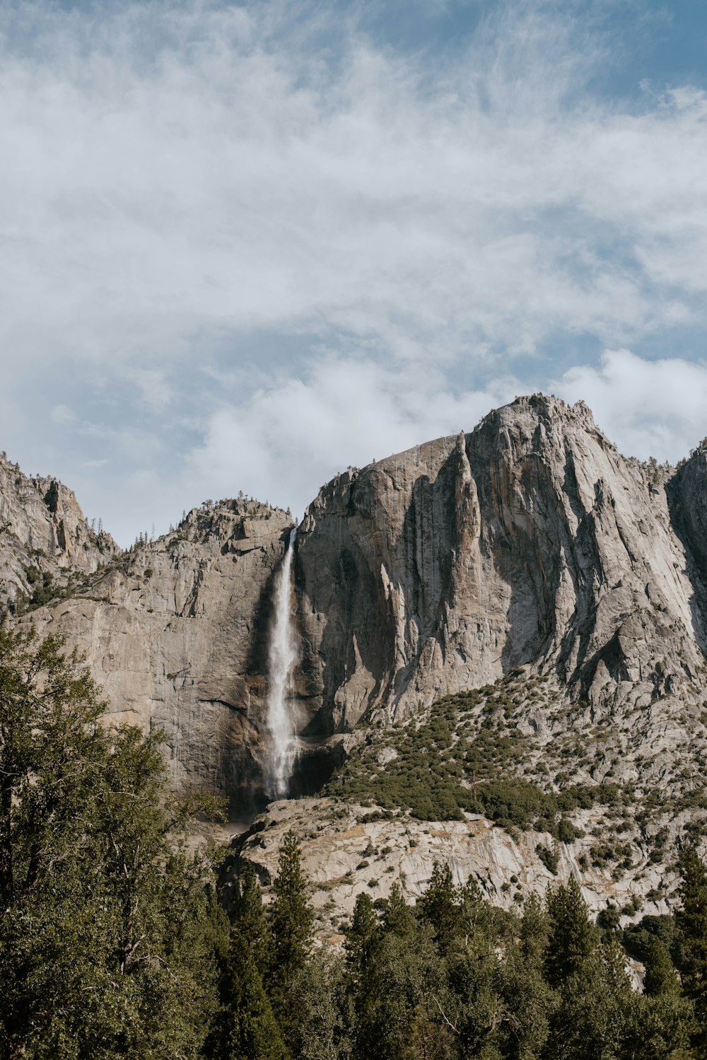 a waterfall is coming out of the side of a mountain