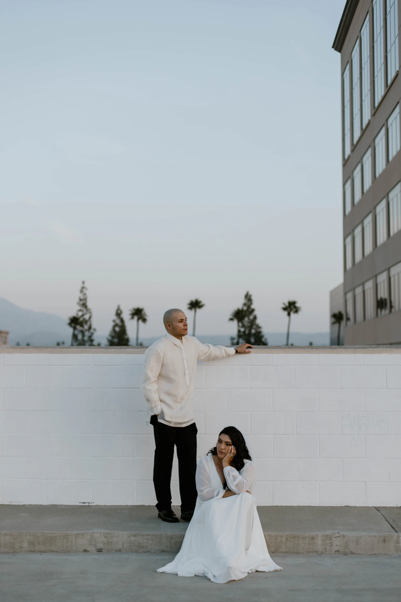 Couple in elegant wedding attire at an intimate outdoor urban elopement ceremony near city architecture