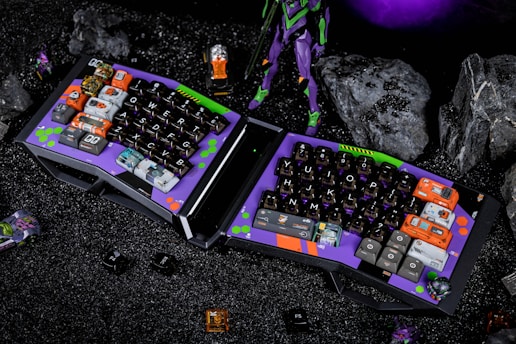 a purple and black computer keyboard sitting on top of a table
