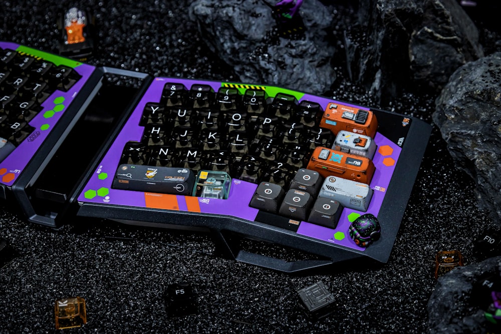 a purple and black keyboard sitting on top of a black table