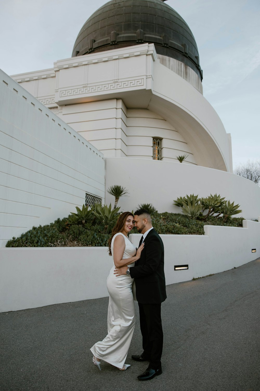 a bride and groom standing in front of a building