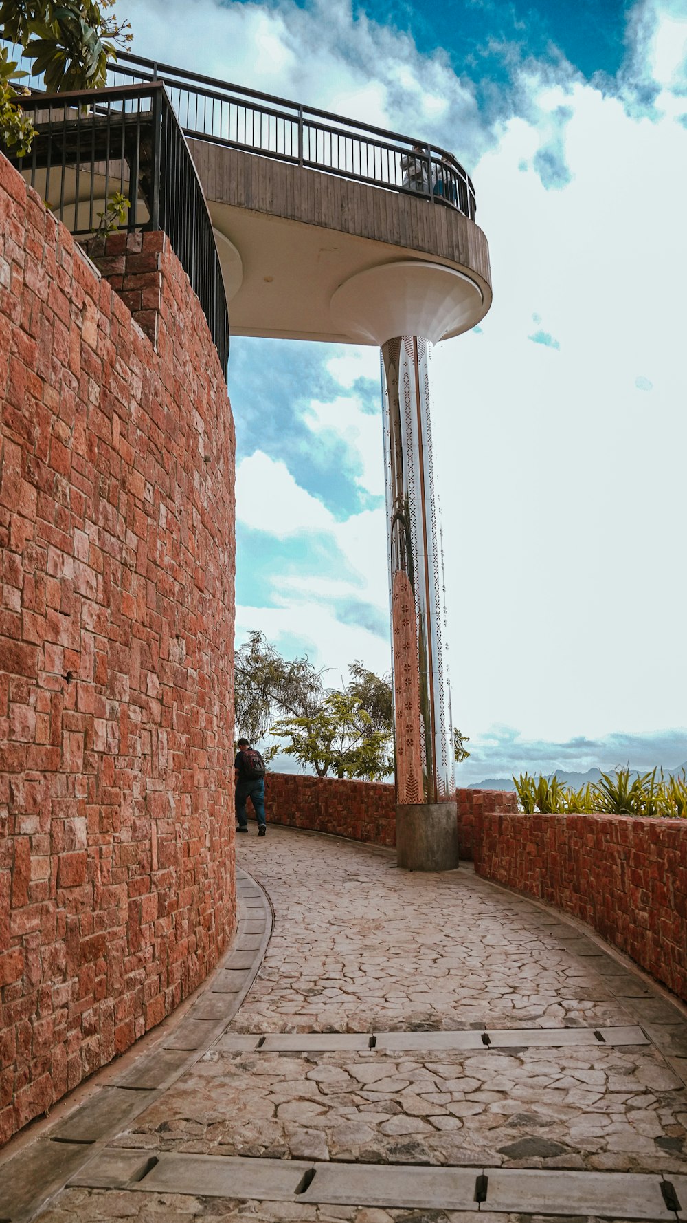 a person sitting on a bench in front of a brick wall