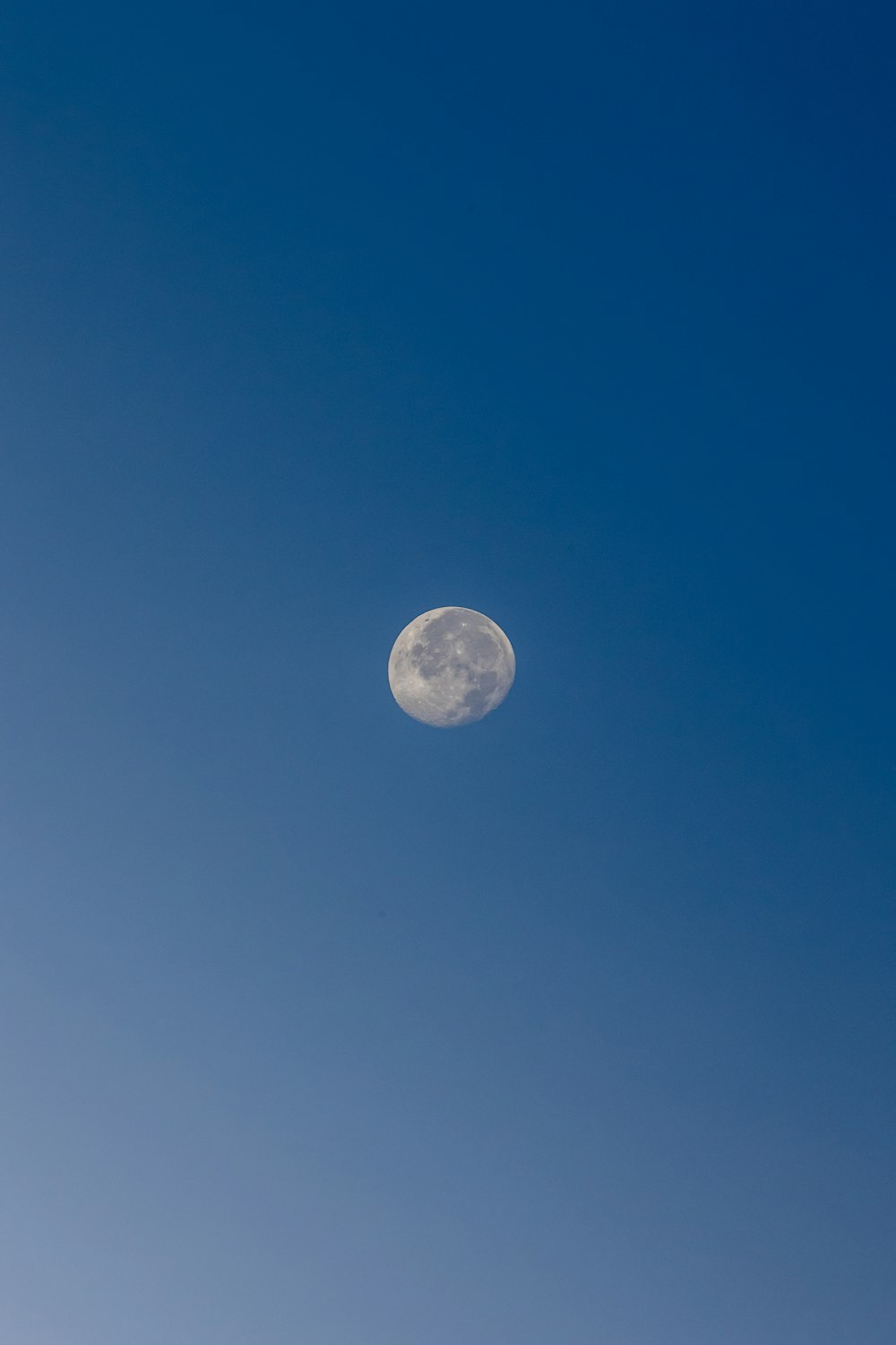 Une pleine lune dans un ciel bleu clair