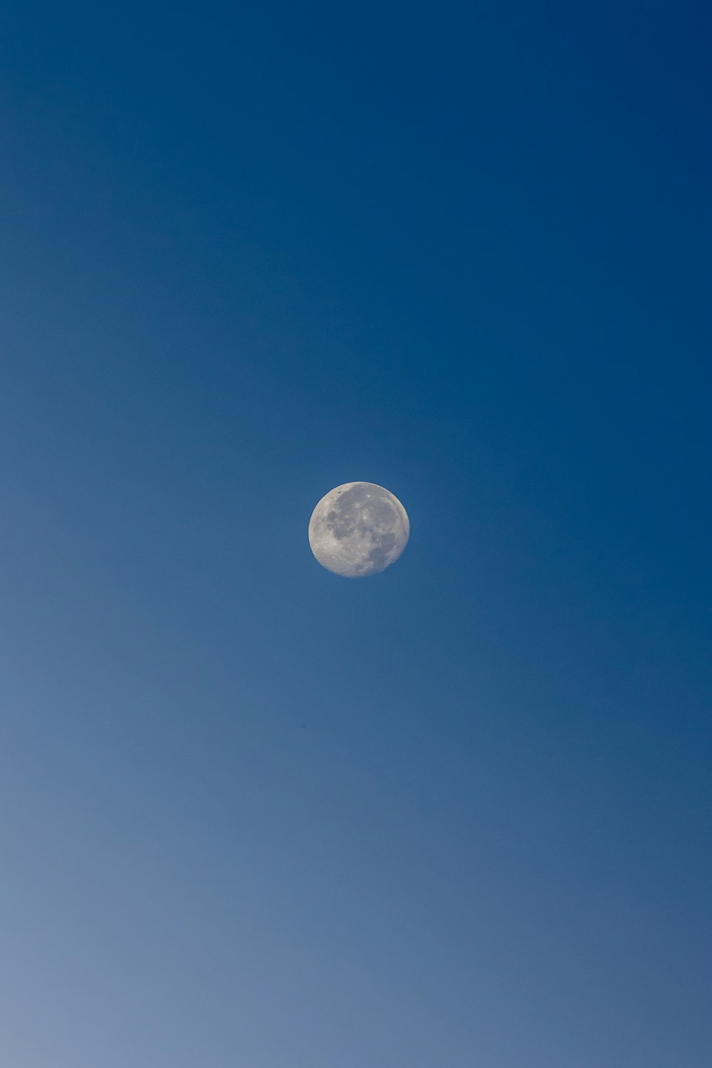 a full moon in a clear blue sky