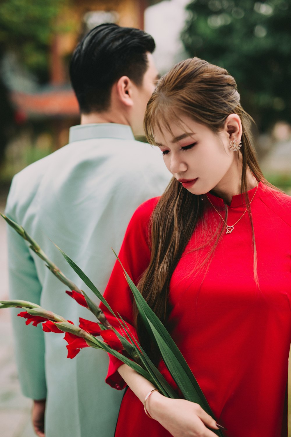 a woman in a red dress holding a bouquet of flowers