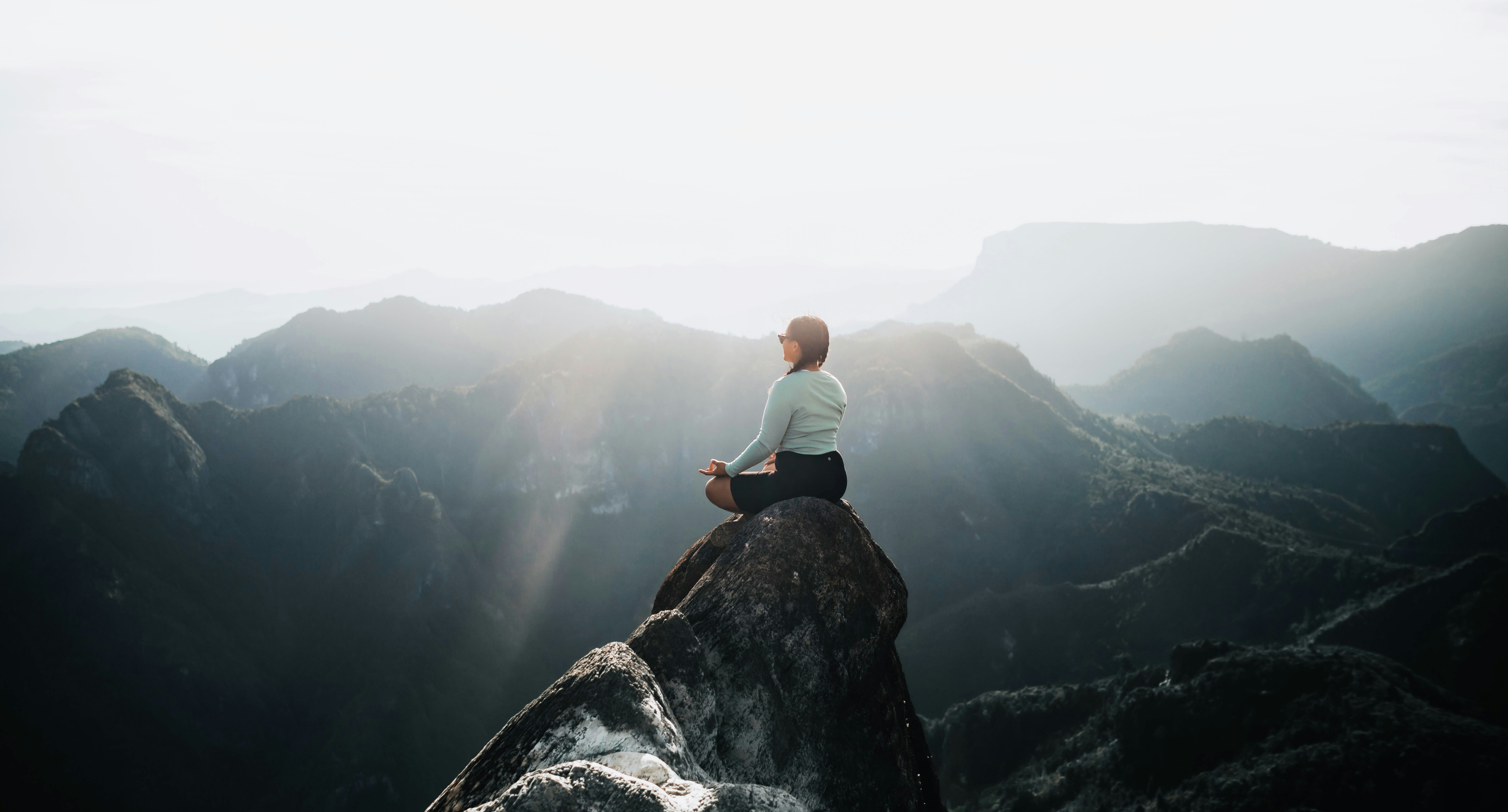 a man sitting on top of a large rock