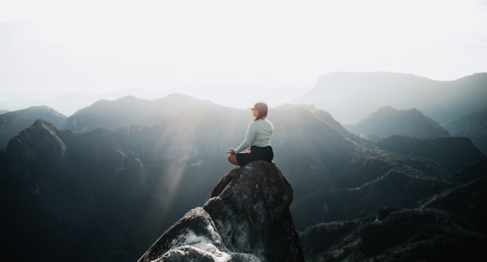 a man sitting on top of a large rock