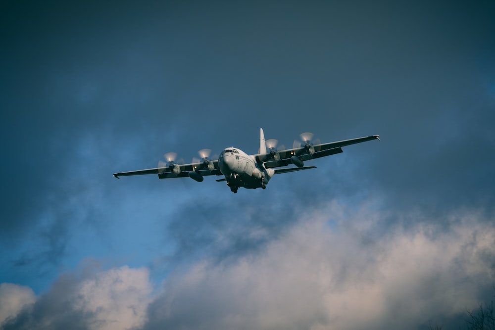 a large air plane flying through a cloudy sky