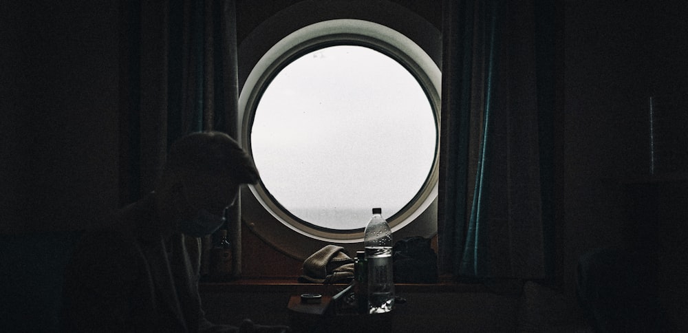 a person sitting in front of a round window
