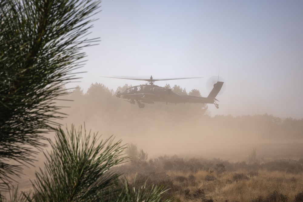 a helicopter is flying low over a field