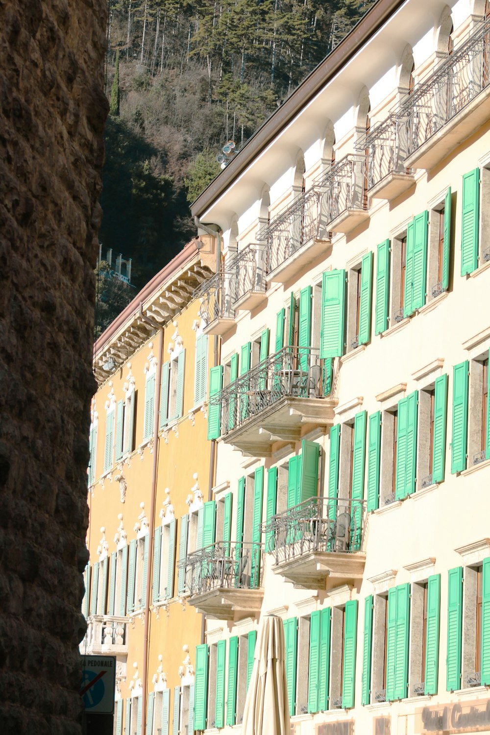 a row of buildings with green shutters and balconies