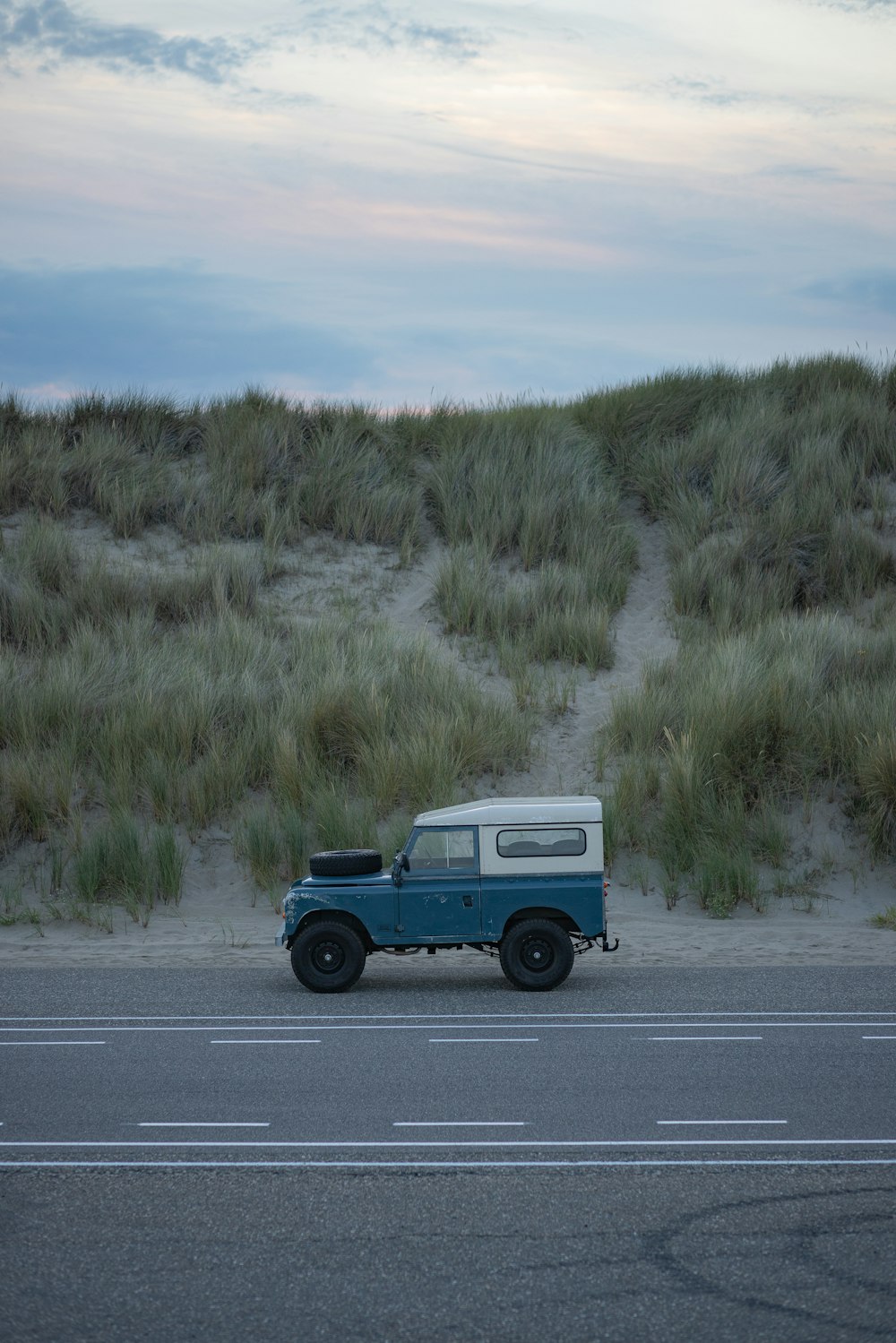 a blue truck parked on the side of a road