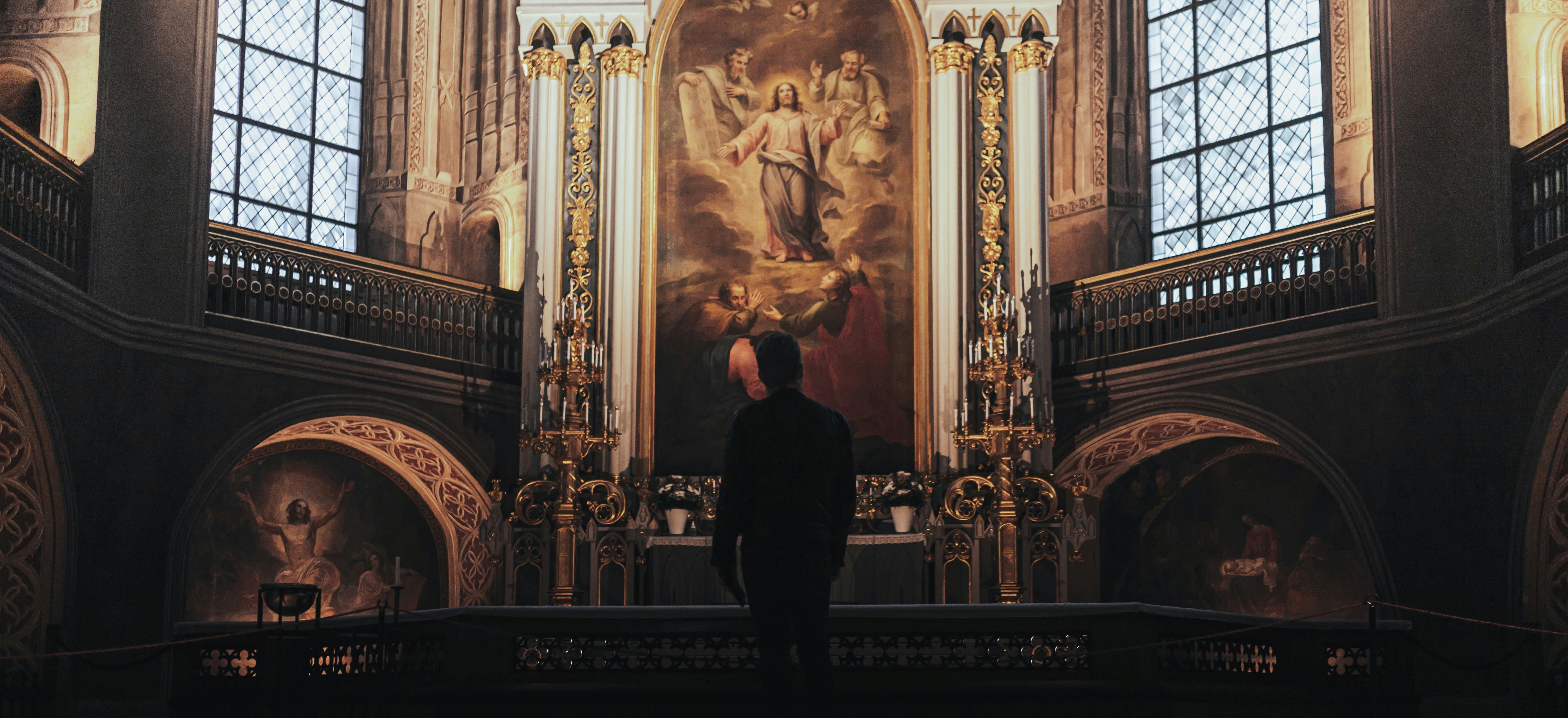 Un homme debout devant un tableau dans une église