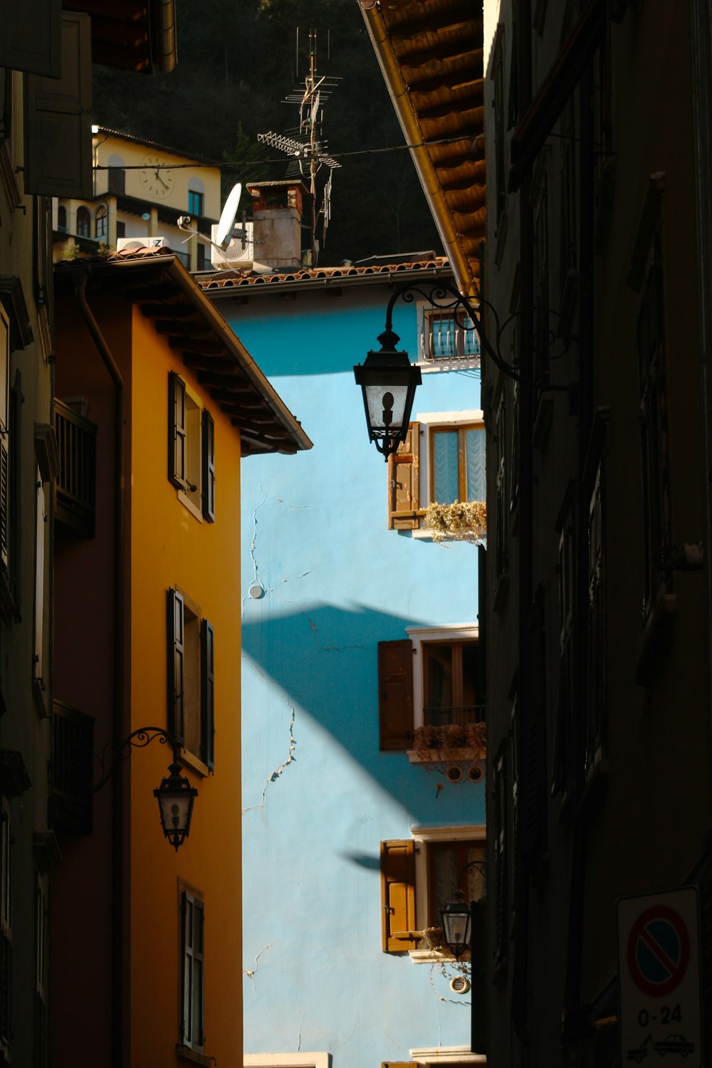 a narrow alley way with a blue building in the background