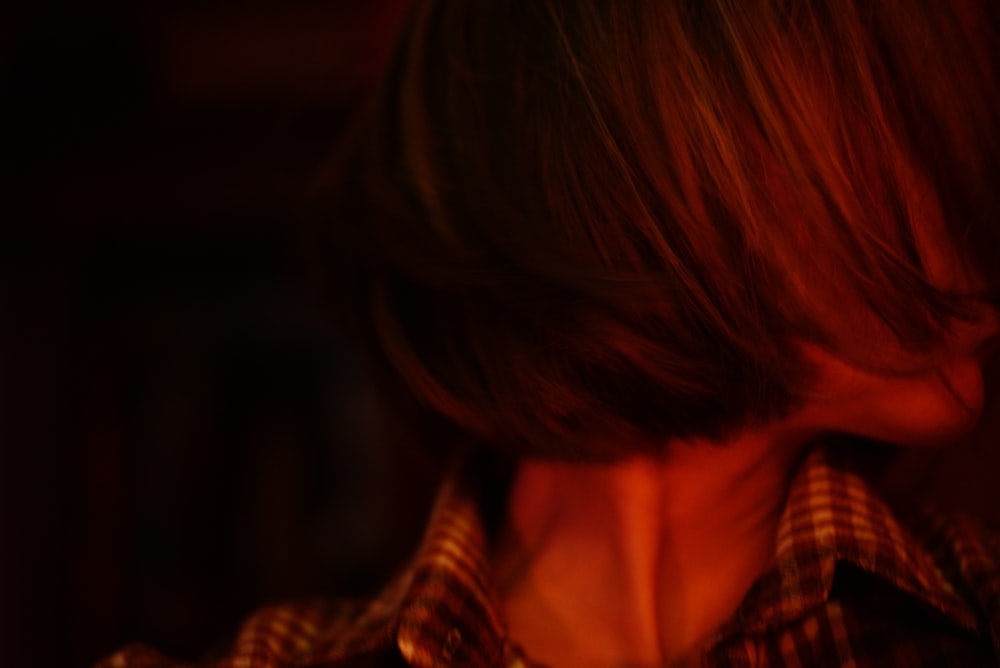 a close up of a person wearing a plaid shirt