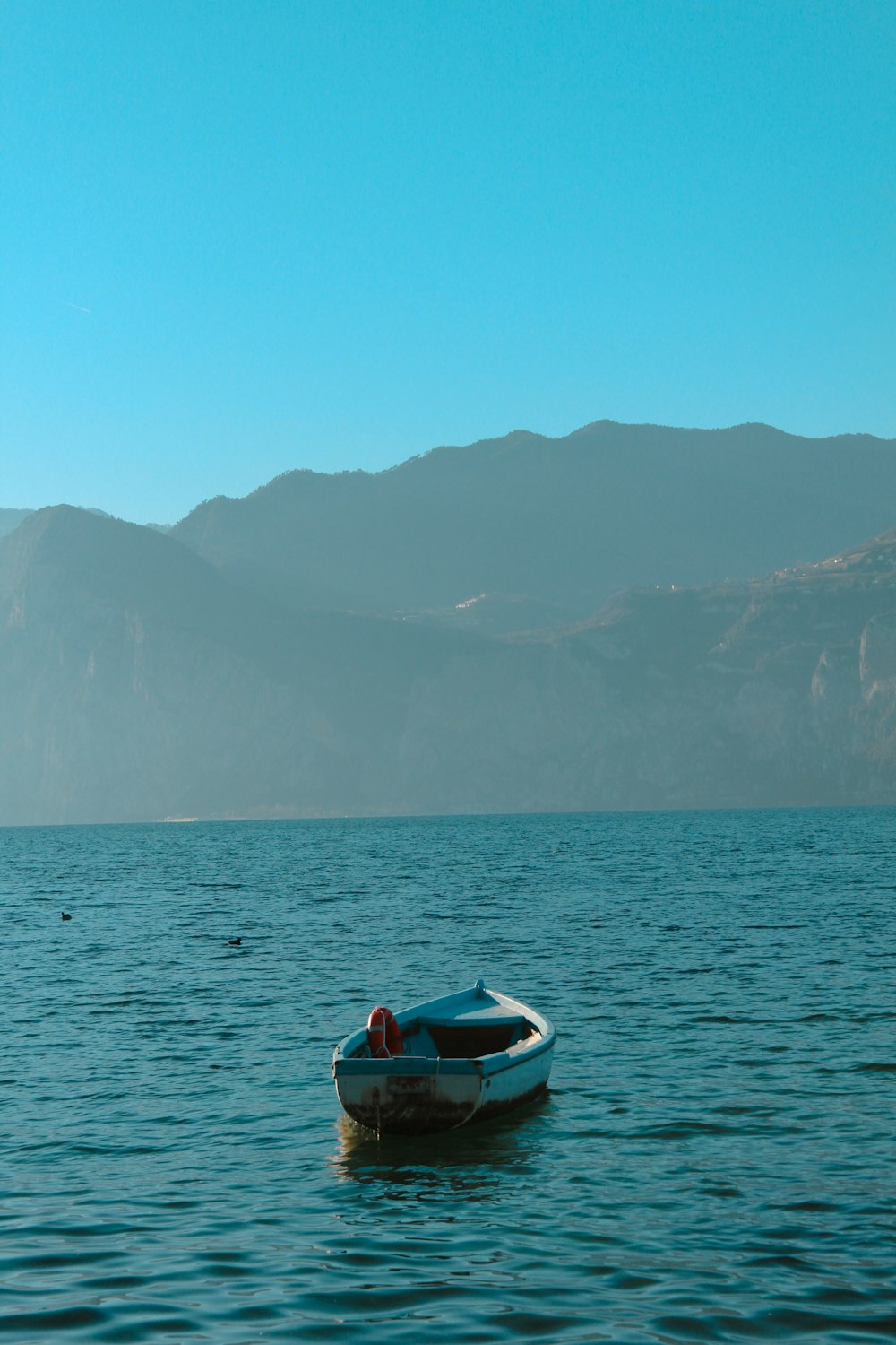 a small boat floating on top of a large body of water