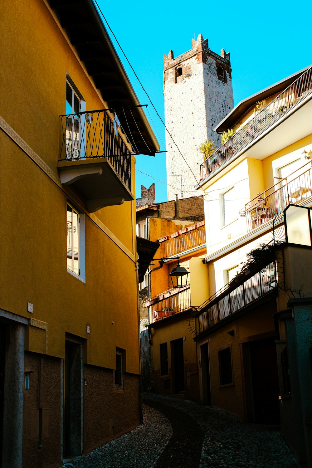 a narrow alley way with a clock tower in the background