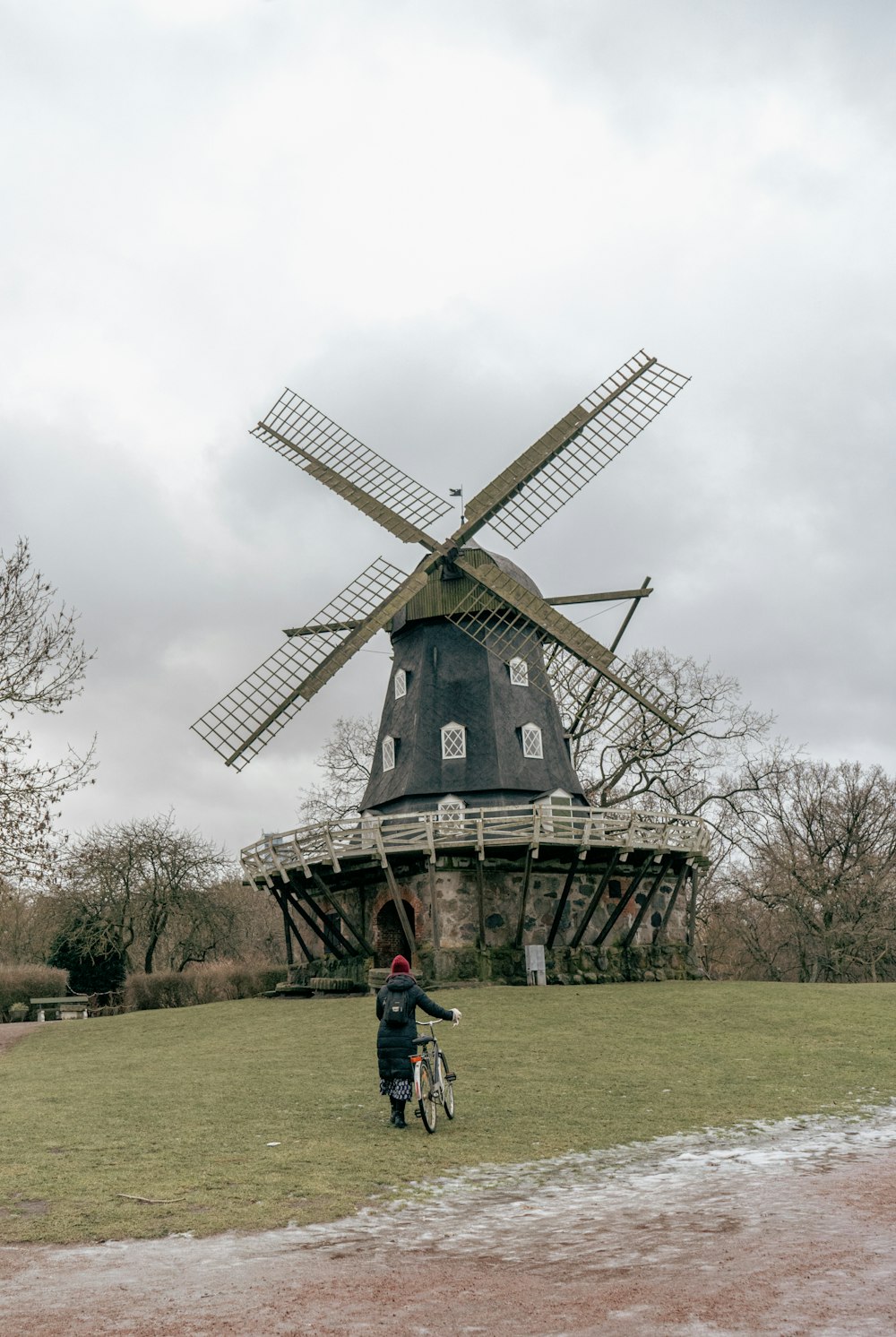 a person on a bike in front of a windmill