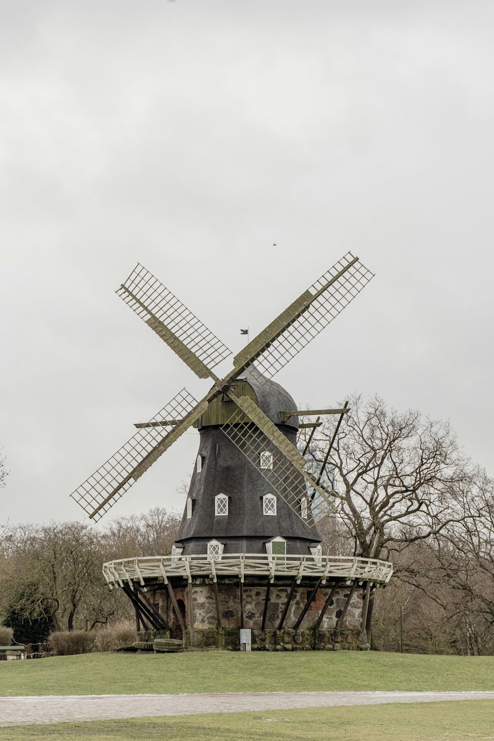 a windmill sitting on top of a lush green field