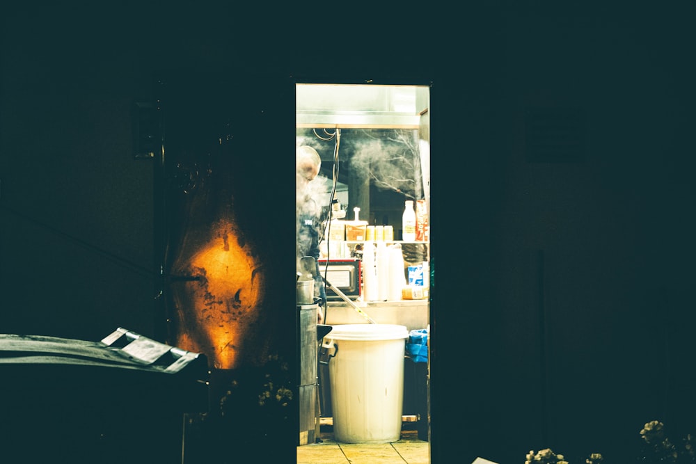 a kitchen with a stove and a trash can