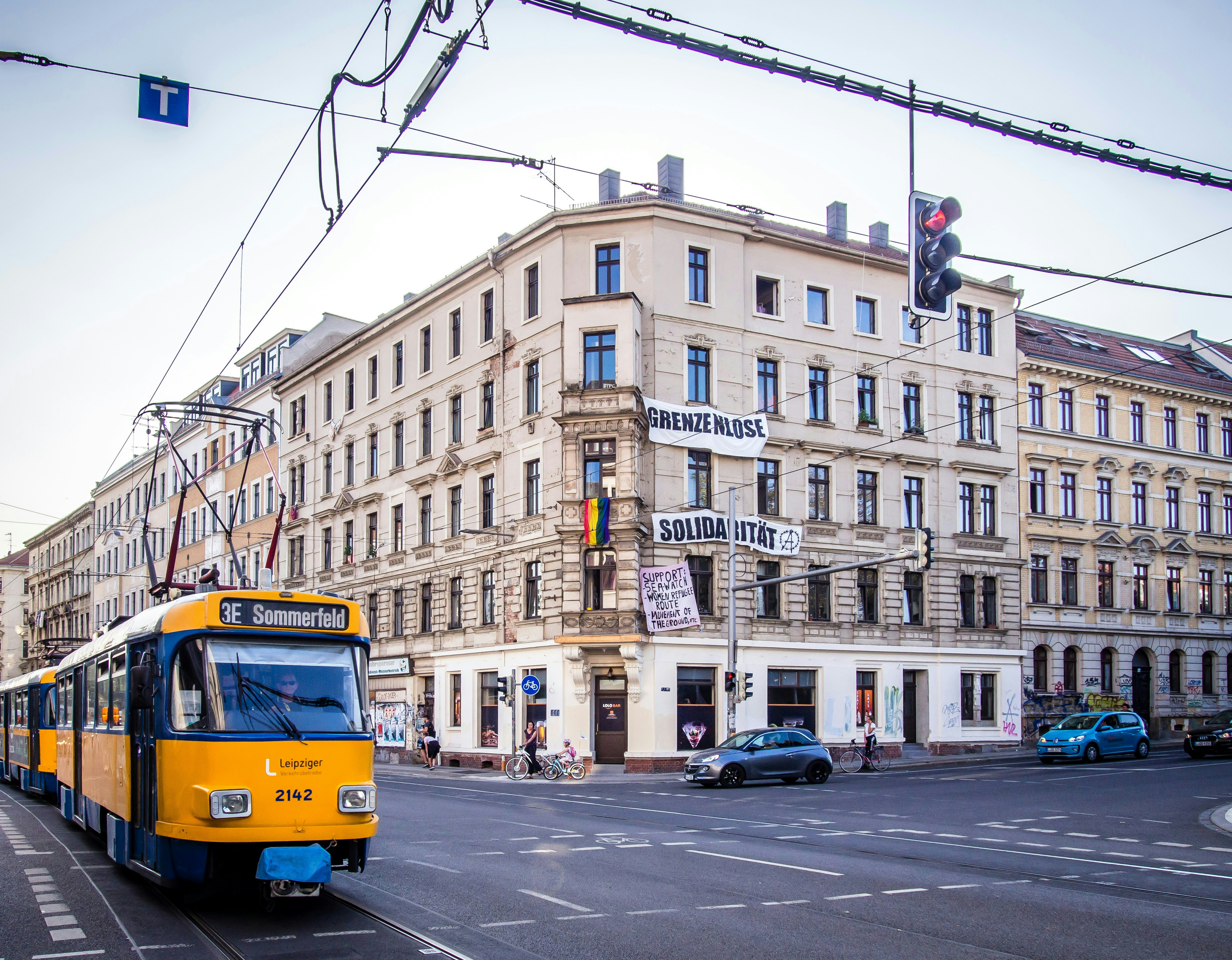 a yellow and blue bus driving down a street next to tall buildings