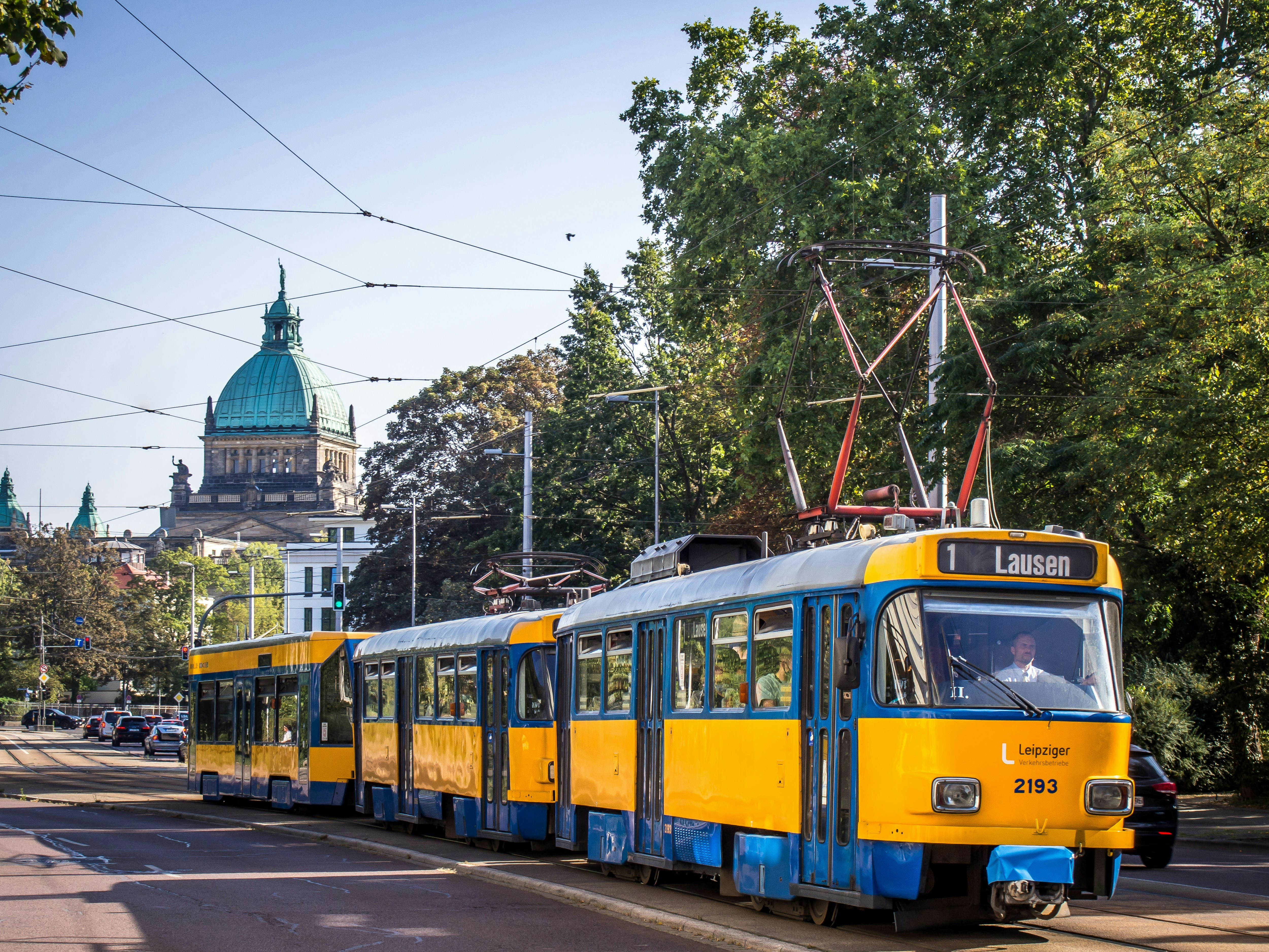 a yellow and blue trolley on a city street